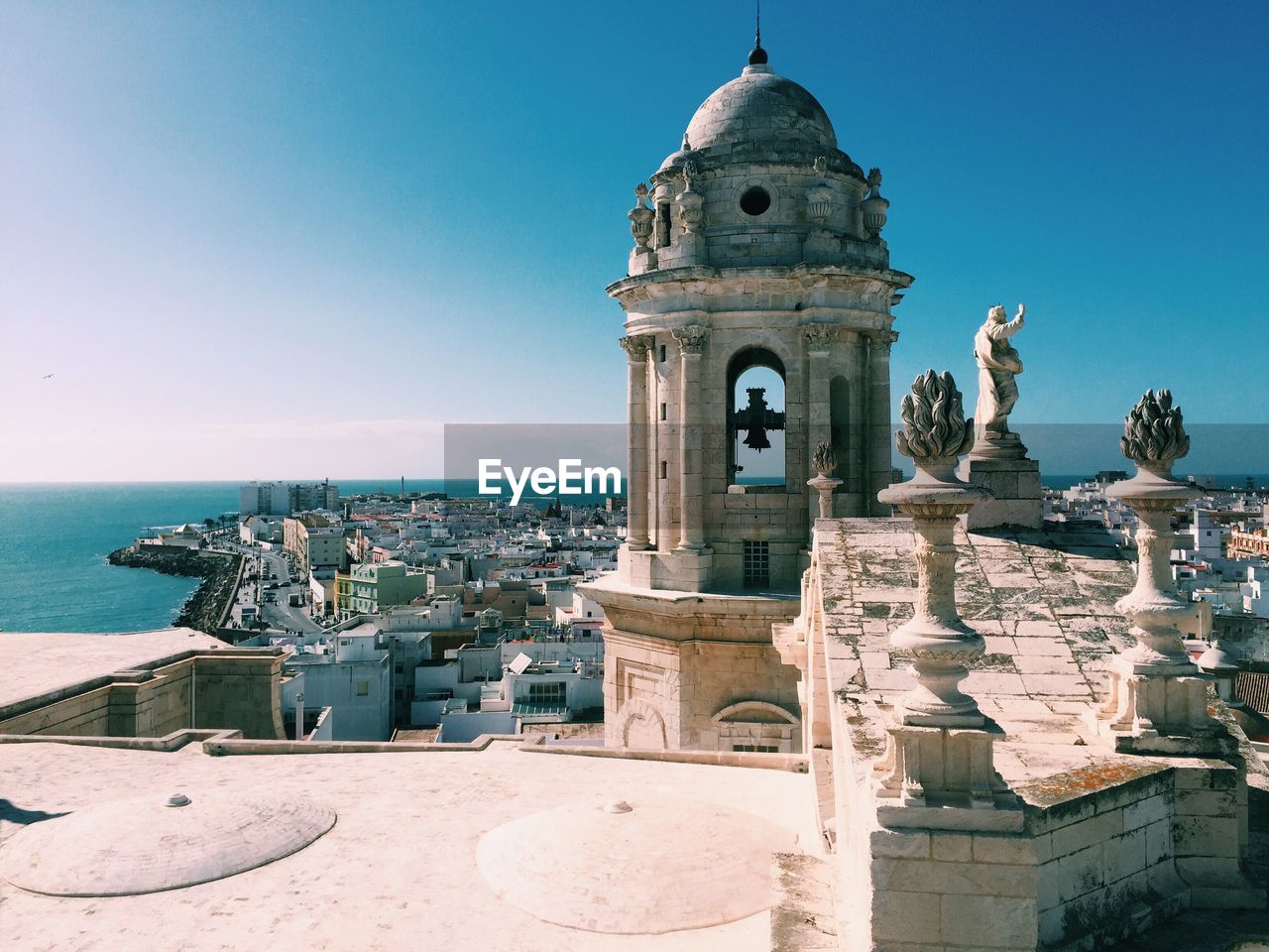 Bell tower against clear blue sky in city