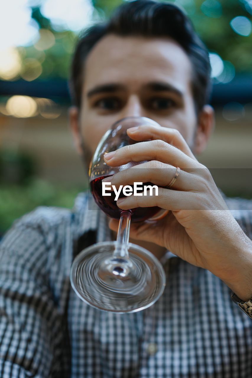 Close-up portrait of man drinking red wine
