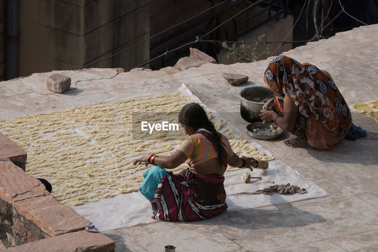 PEOPLE SITTING ON COBBLESTONE