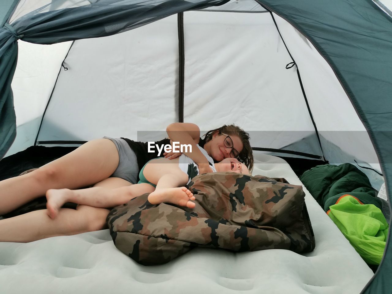 High angle view of woman and boy playing in tent