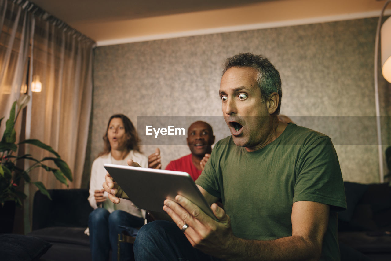 Disappointed and shocked man using digital tablet during sporting event