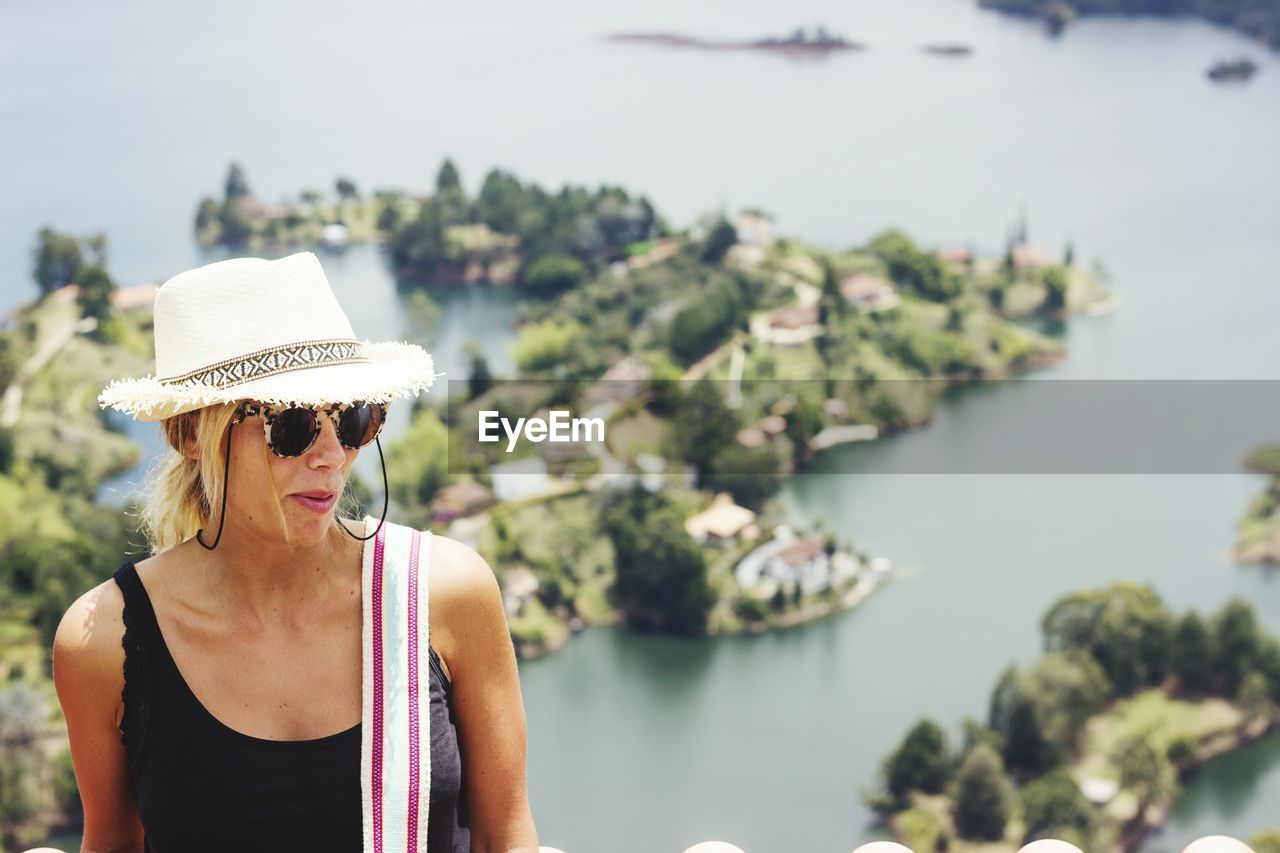 Woman wearing hat against lake