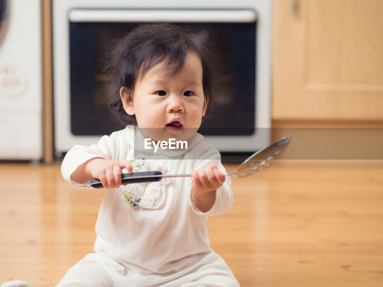 Cute boy playing with colander at home