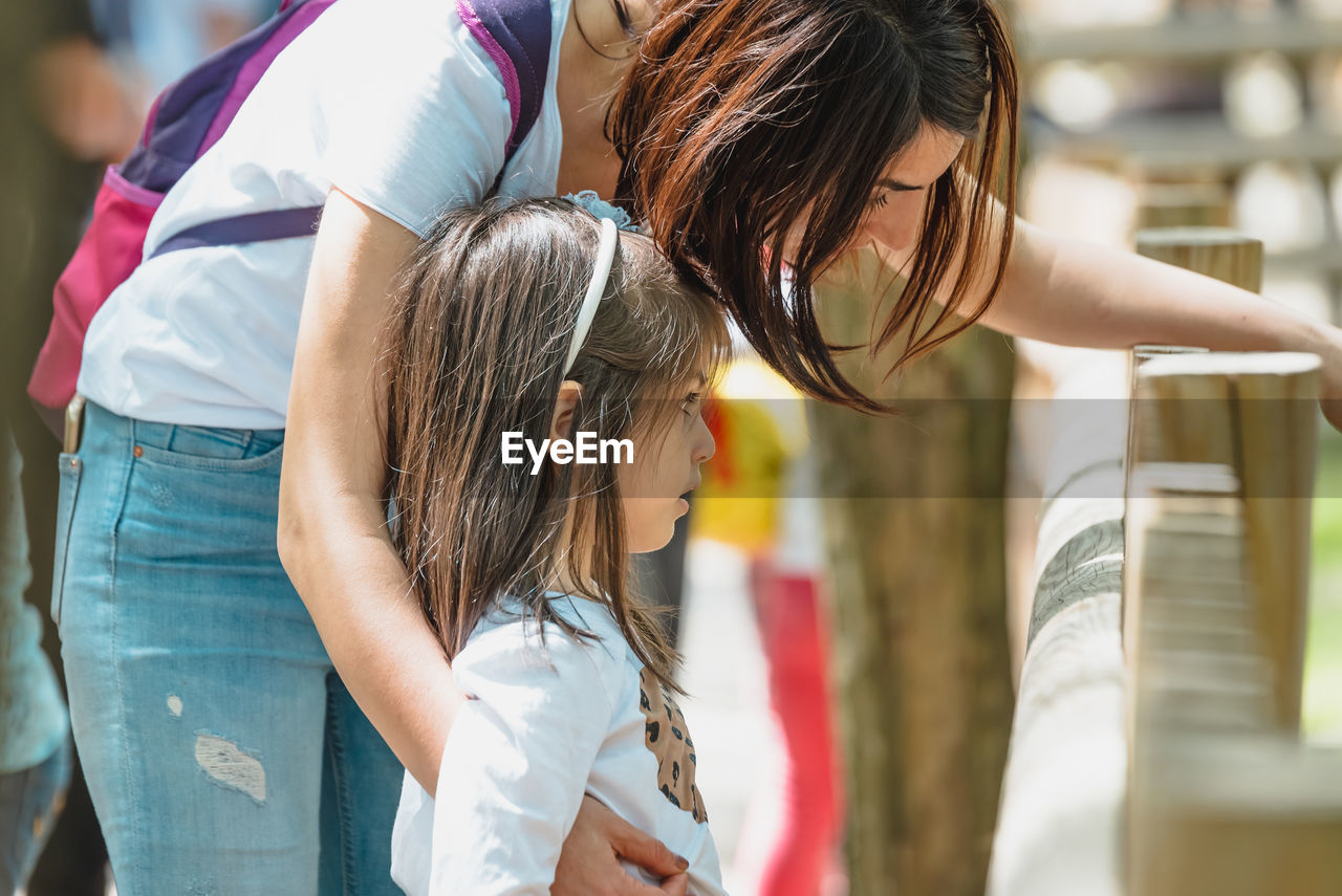 Girl with mother standing at park