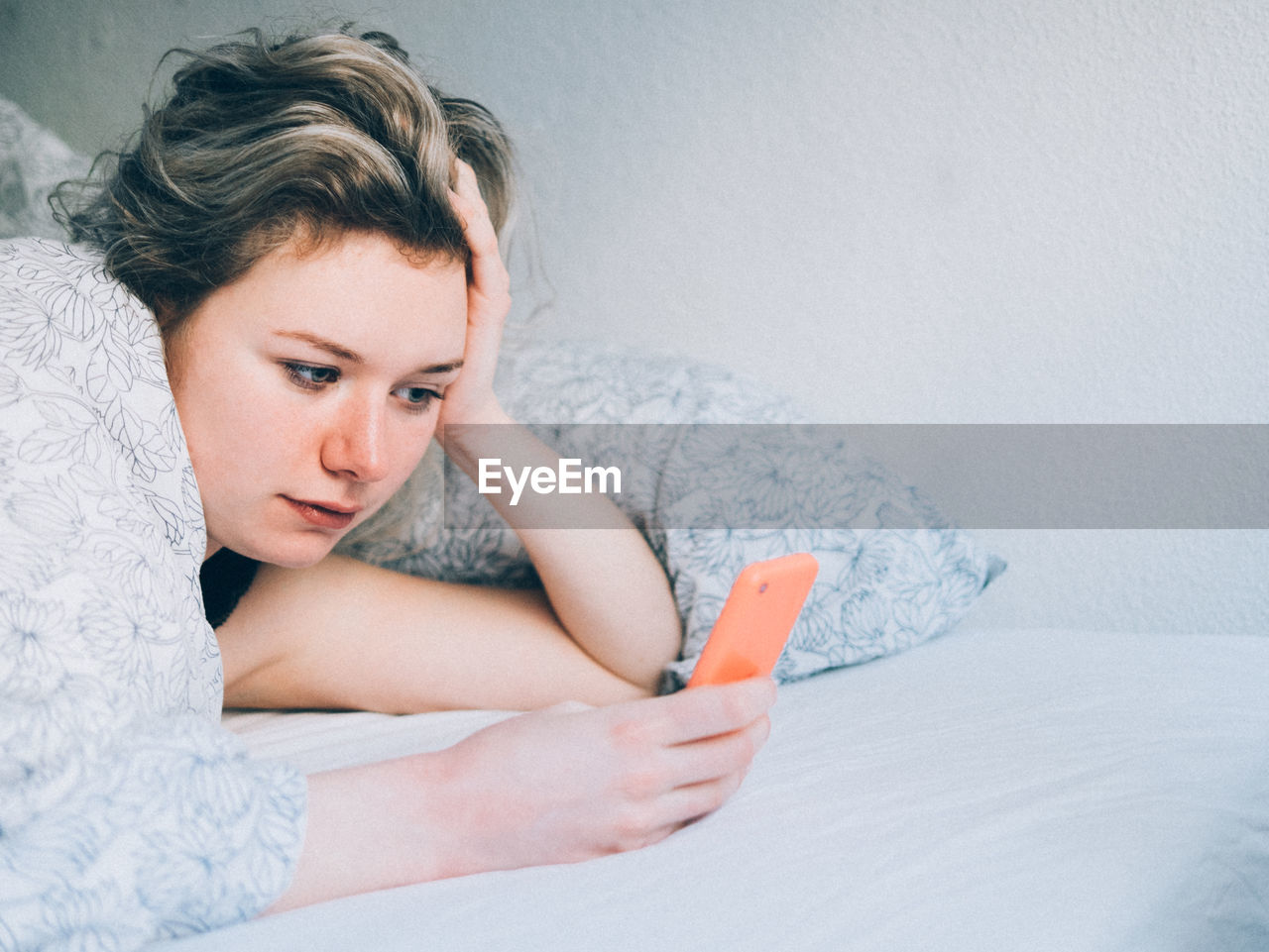 Woman in bed using phone