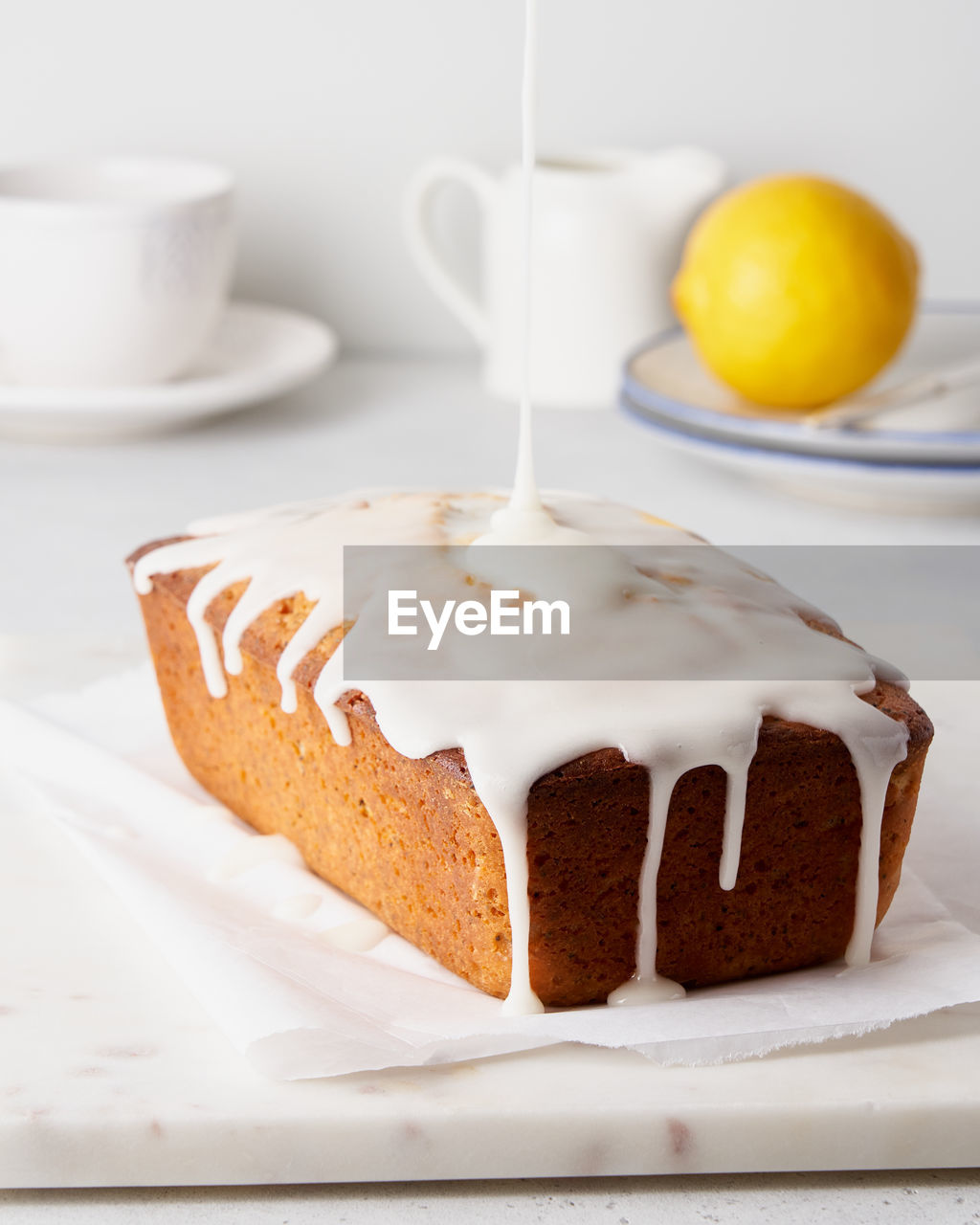 Lemon bread with poppy seeds pouring with white icing. sweet morning breakfast