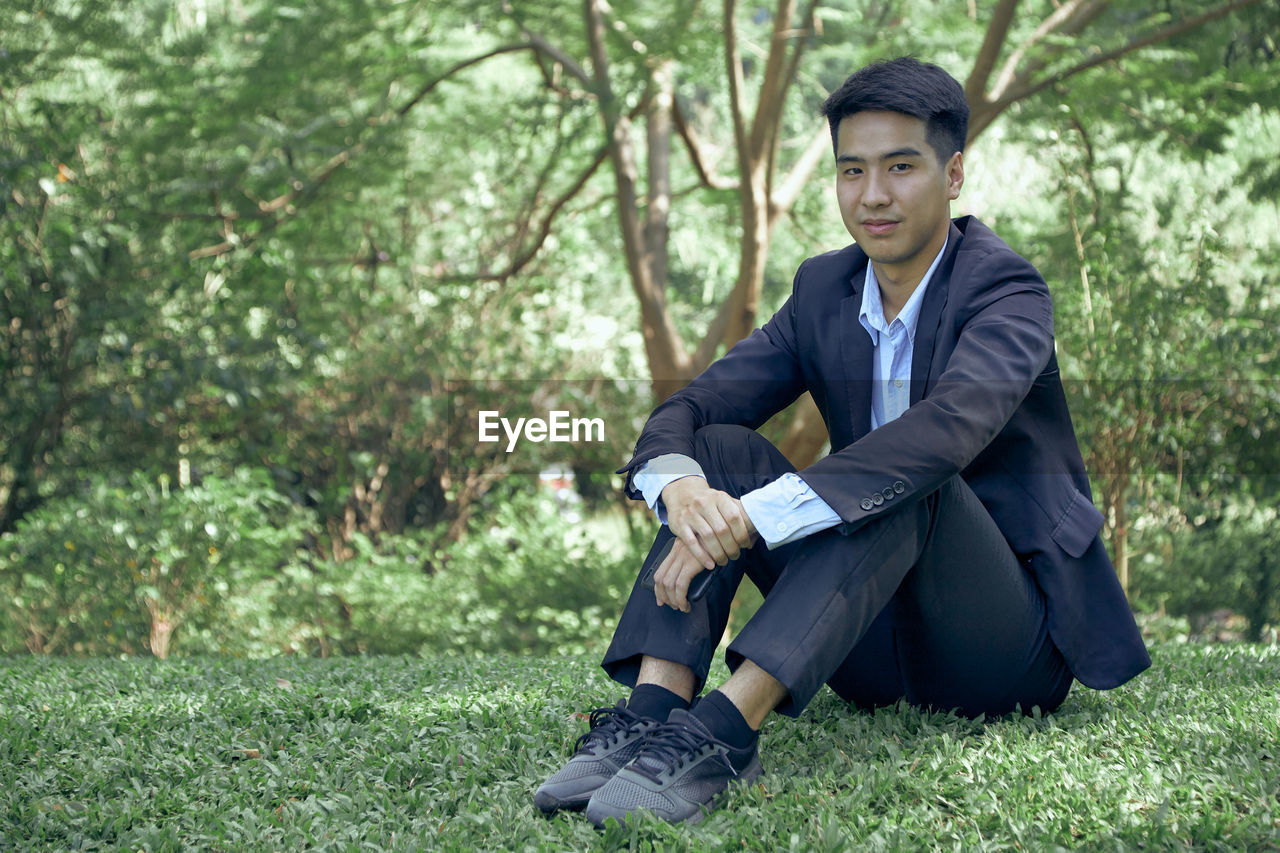 Full length of a young man sitting on land