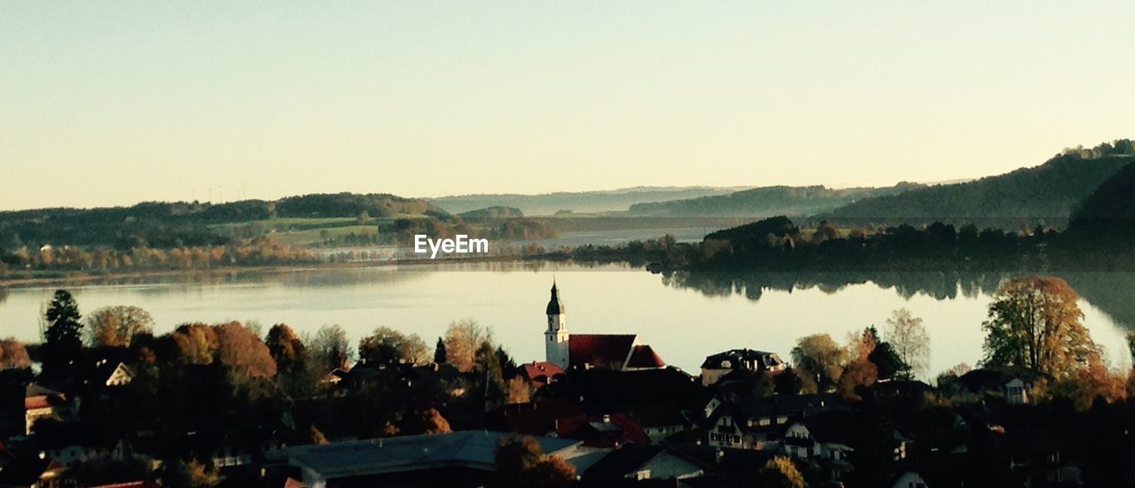 Scenic view of river by town against sky