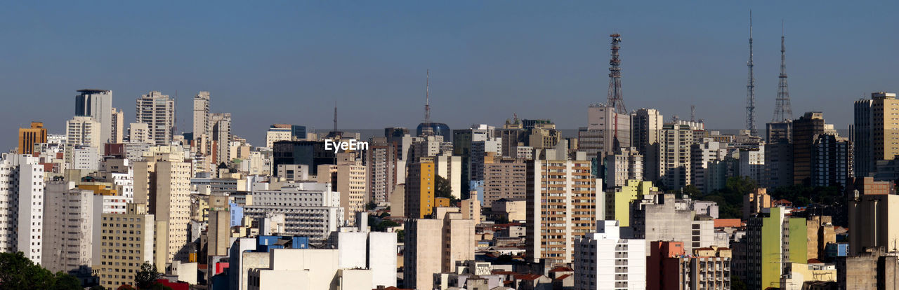 Aerial view of modern buildings in city against clear sky