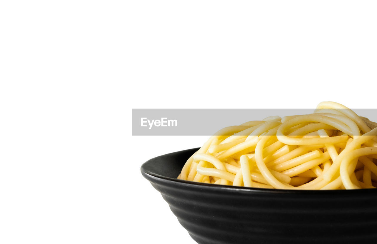 CLOSE-UP OF NOODLES IN BOWL WITH WHITE BACKGROUND