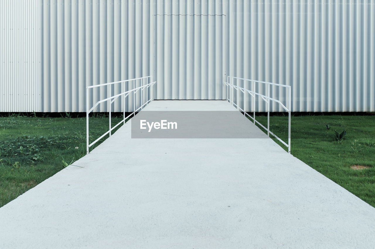 Footbridge leading towards corrugated iron