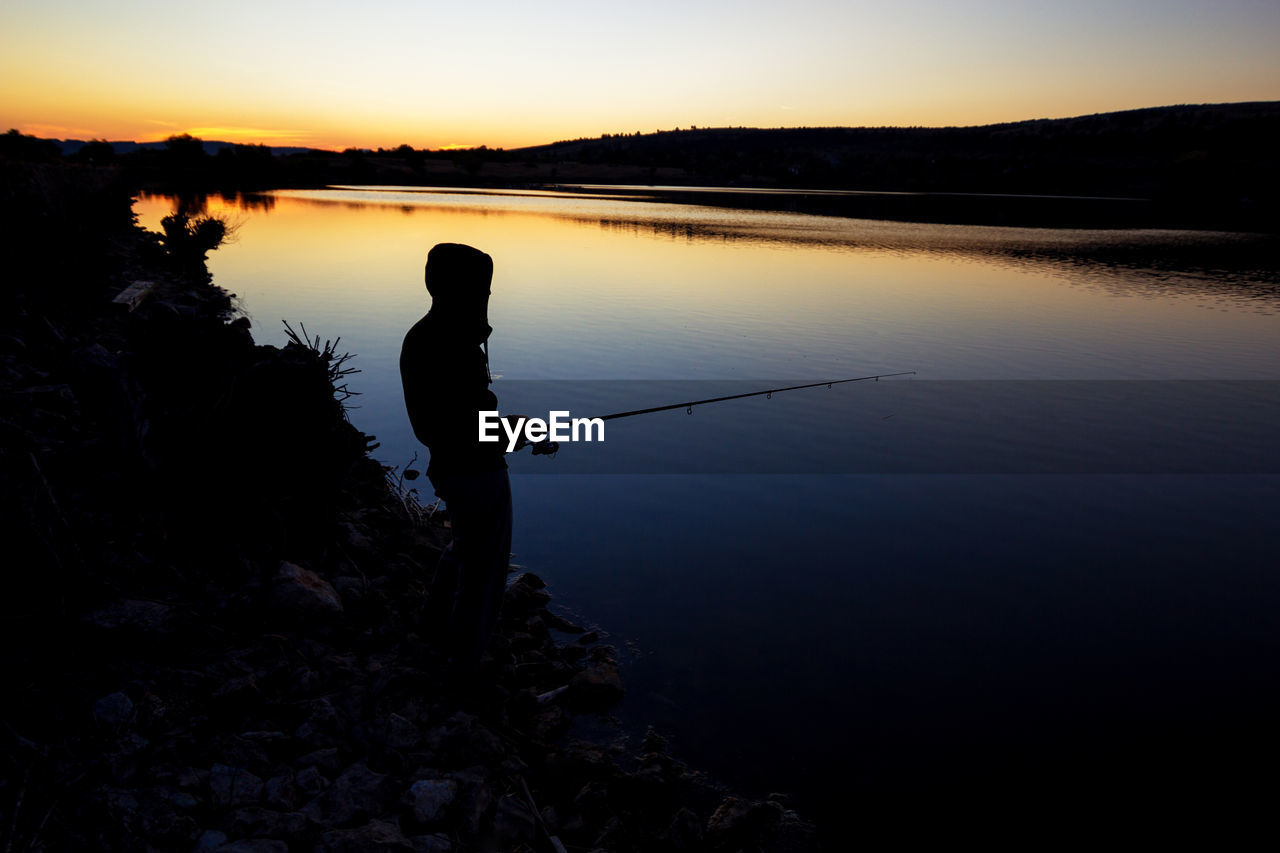 Fishing at sunset near the sea.