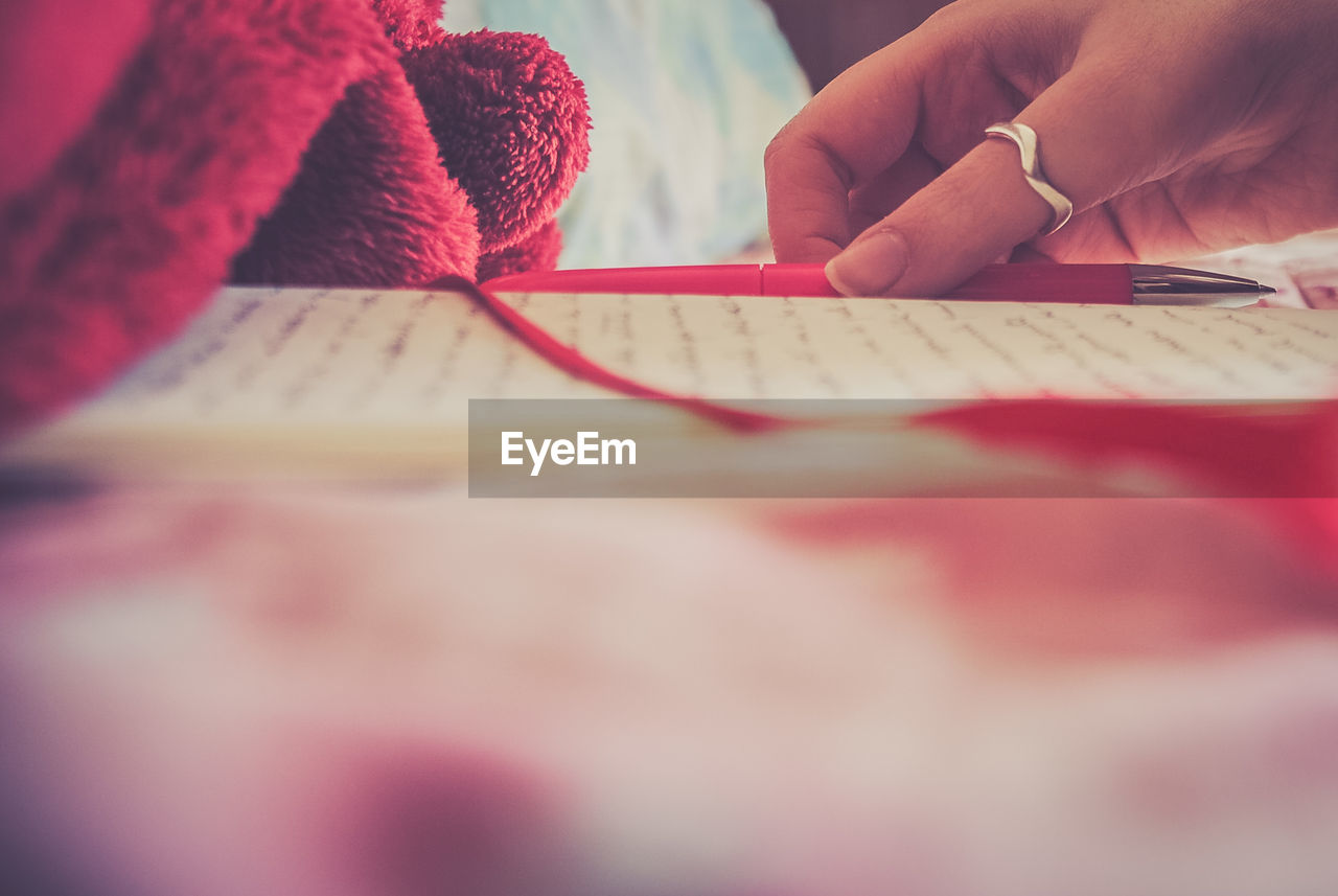 Cropped image of woman writing in book