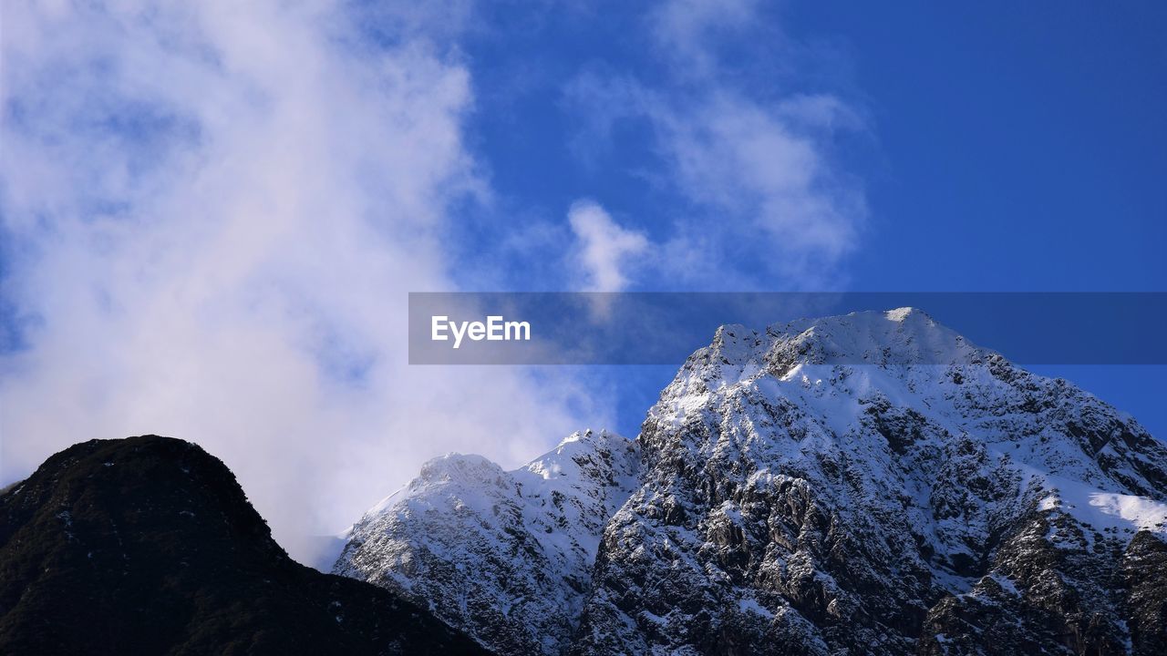 Low angle view of snowcapped mountain against sky