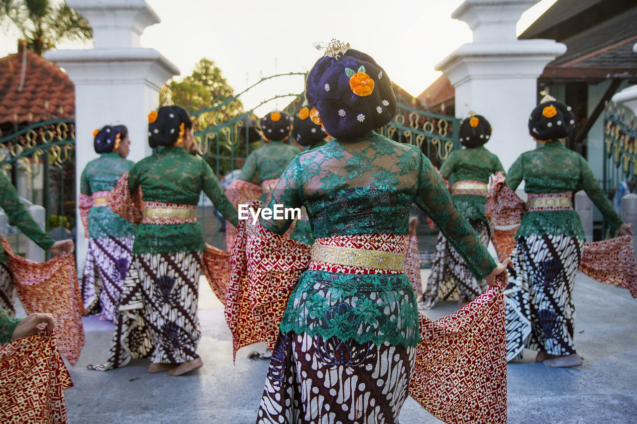 Group of women wearing traditional clothing while dancing in city