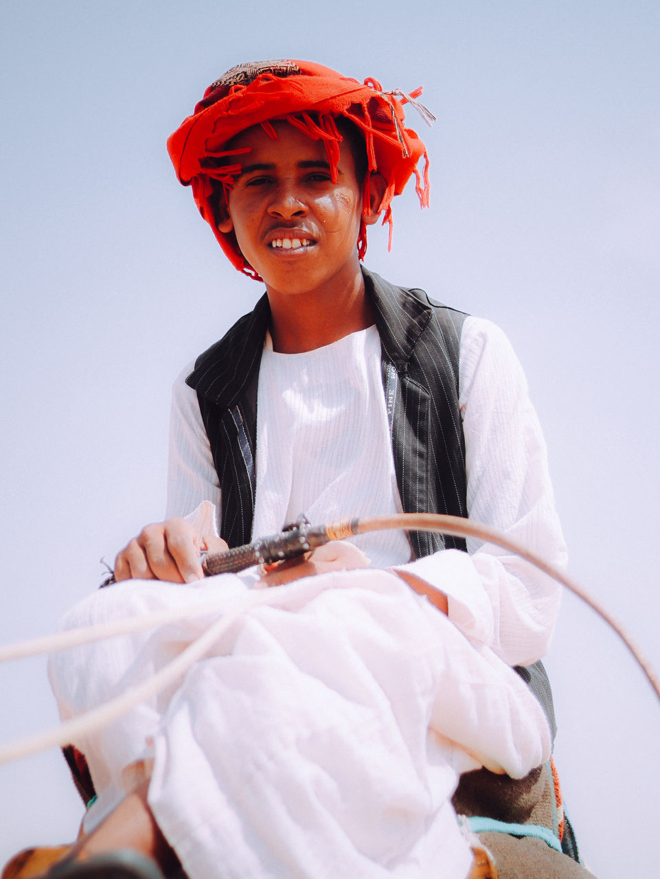 Portrait of bedouin young man on his camel in the desert 