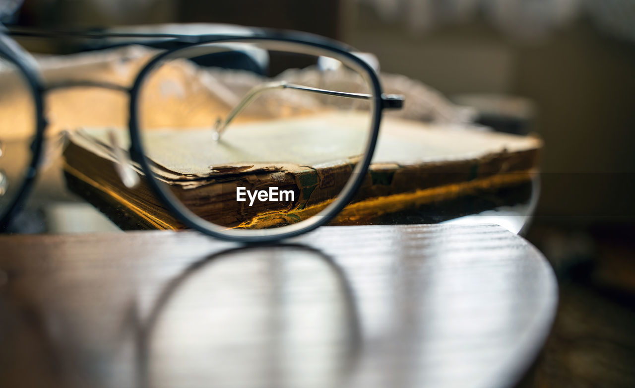 Time and knowledge concept, an eye glasses or spectacles kept in front of a really old torn book