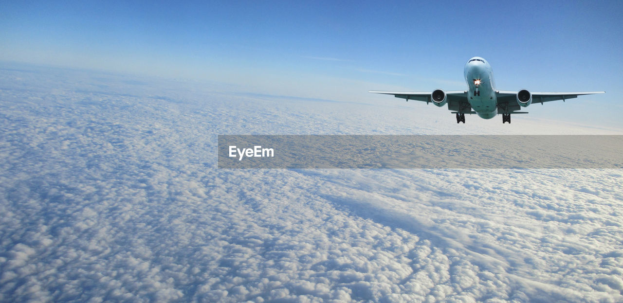 LOW ANGLE VIEW OF AIRPLANE FLYING IN SNOW