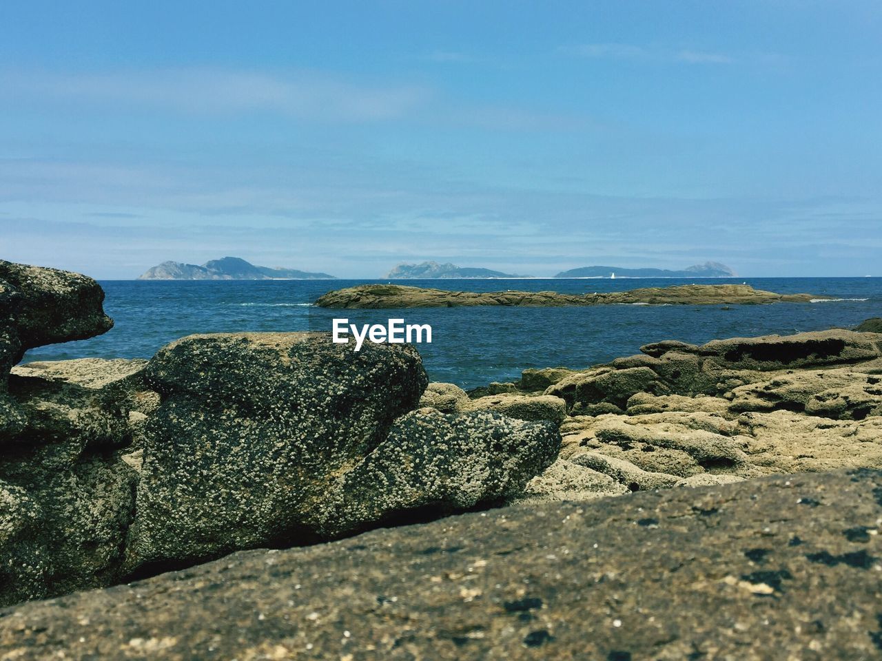 Rocks by sea at cies islands against sky