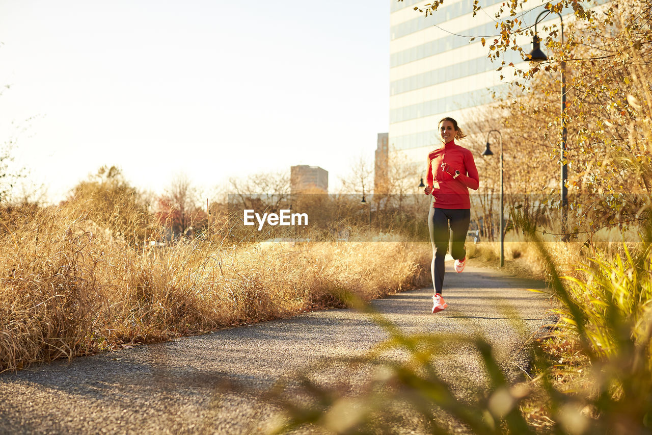 A woman on a run through the park on a warm fall day.