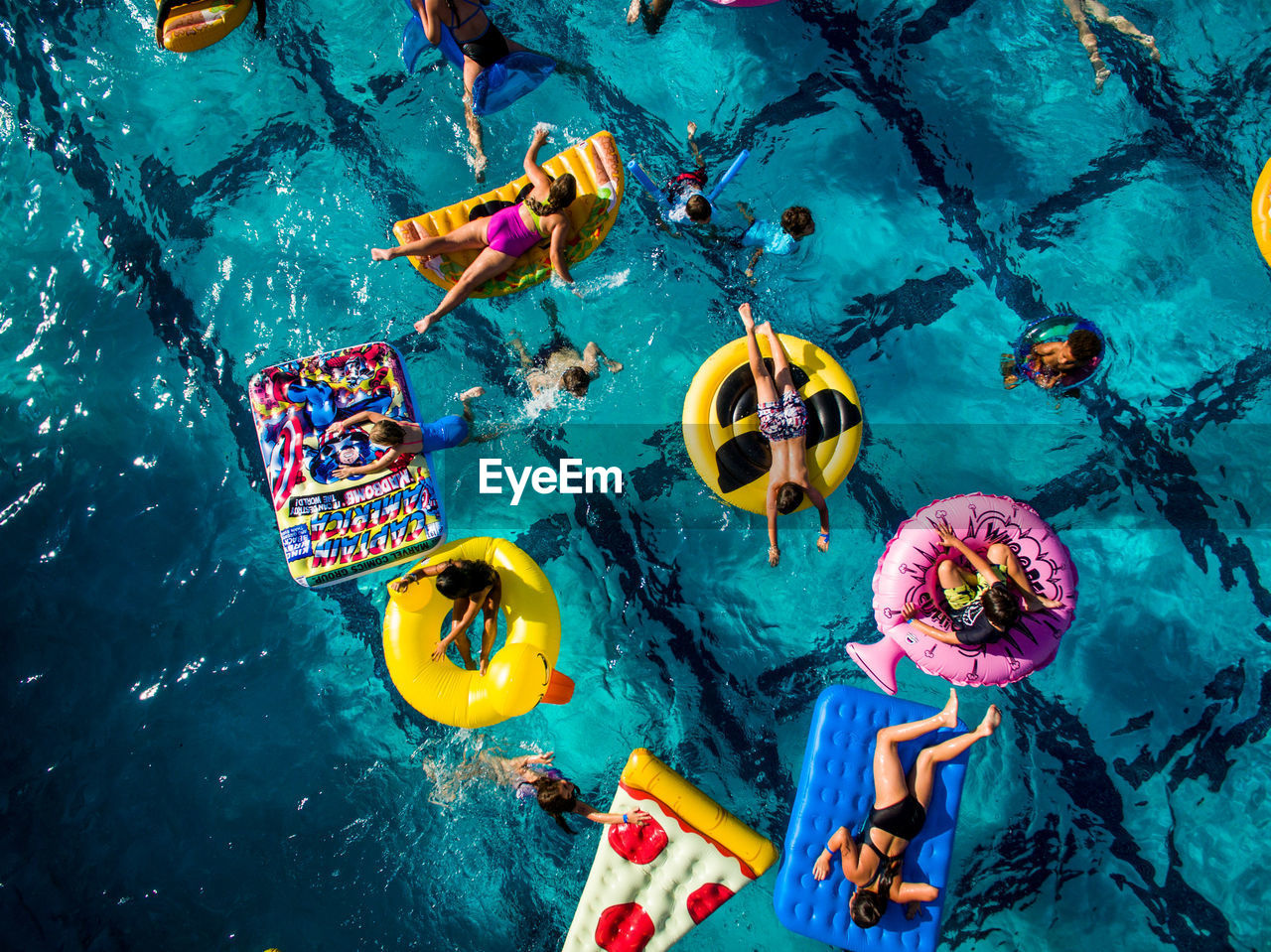 HIGH ANGLE VIEW OF PEOPLE IN SWIMMING POOL