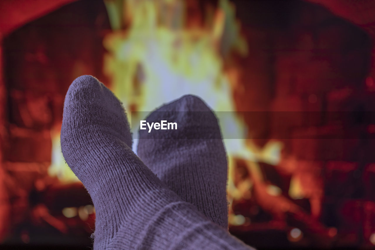 red, one person, human leg, low section, adult, limb, human limb, heat, darkness, focus on foreground, personal perspective, fireplace, lifestyles, shoe, human foot, women, night, nature, hand, close-up, fire, leisure activity