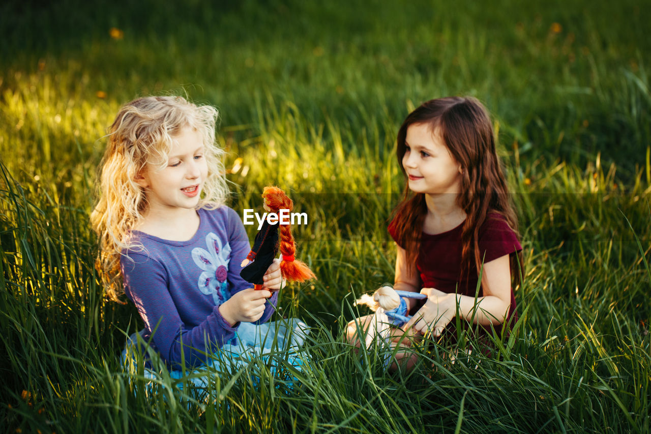 Happy children girls playing dolls in park. happy childhood authentic lifestyle. outdoor summer 