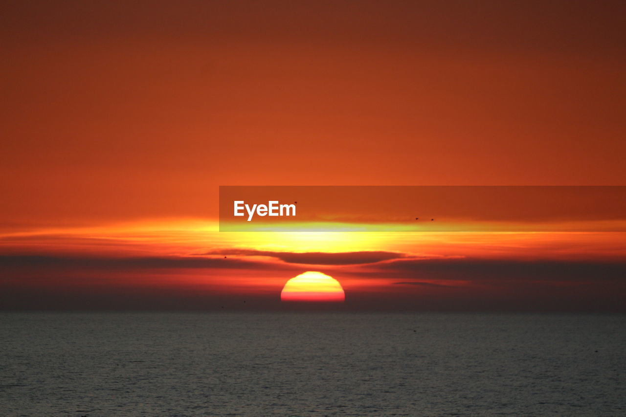 Scenic view of sea against romantic sky at sunset