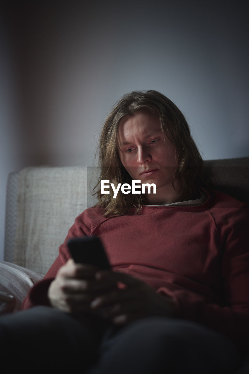 Man on bed using cell phone