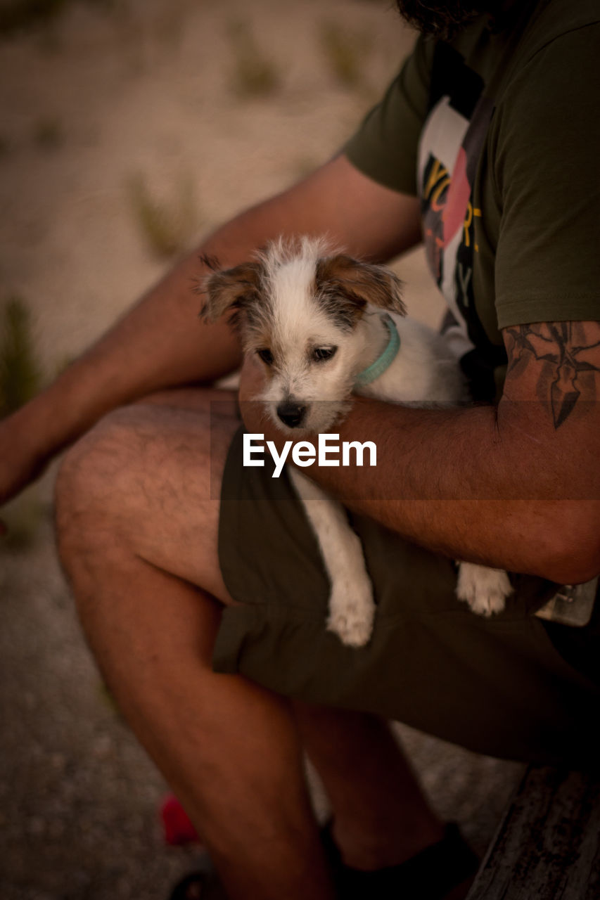 REAR VIEW OF MAN WITH DOG ON BLANKET