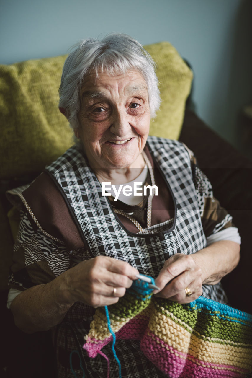 Portrait of smiling senior woman with knitting