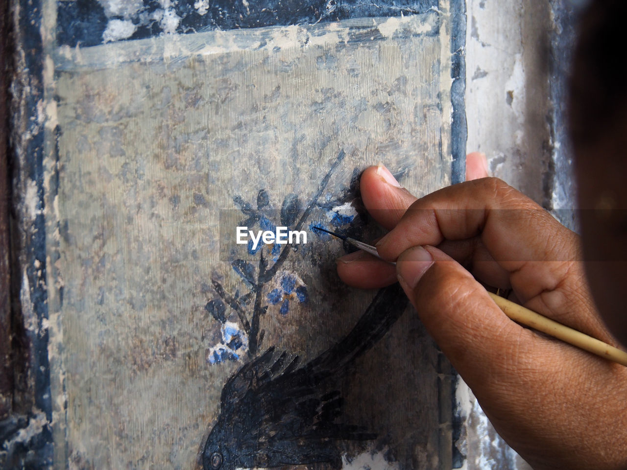 Close-up of hand painting on wall