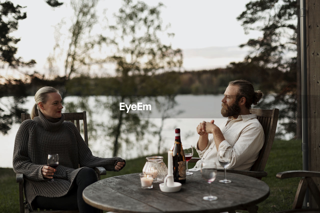 Couple sitting on porch and drinking wine