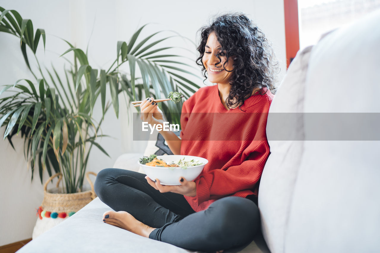 Brunette woman eating a healthy green salad.