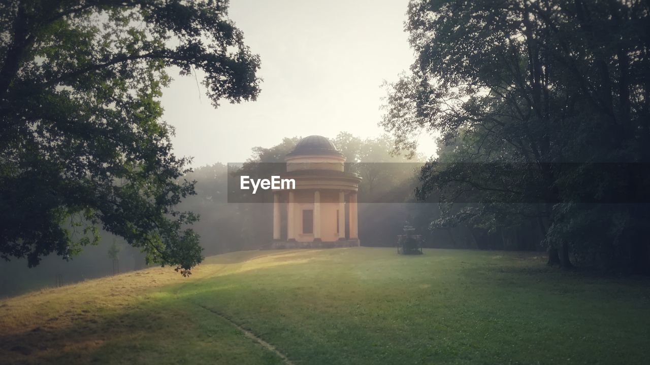 Gazebo by trees in park against sky