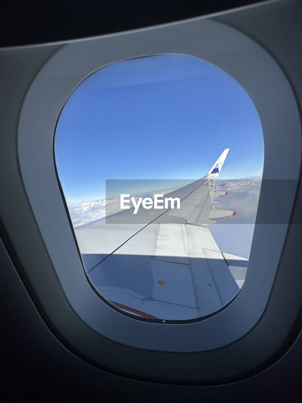 airplane, air vehicle, transportation, mode of transportation, flying, window, travel, aircraft wing, sky, vehicle, no people, vehicle interior, journey, nature, aerial view, glass, mid-air, blue, aerospace industry, screenshot, outdoors, looking, day, cloud