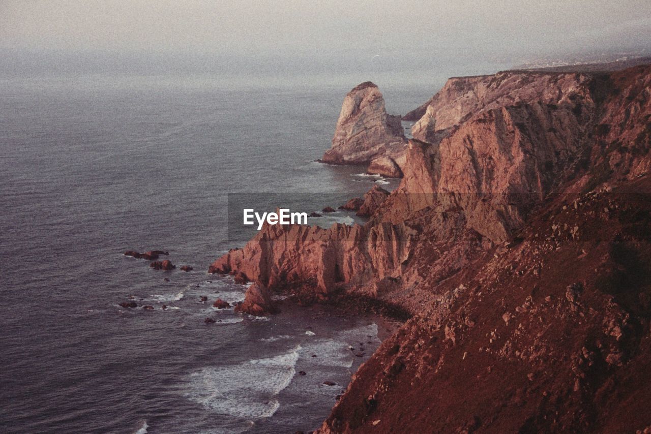 High angle view of rock formation by sea against sky