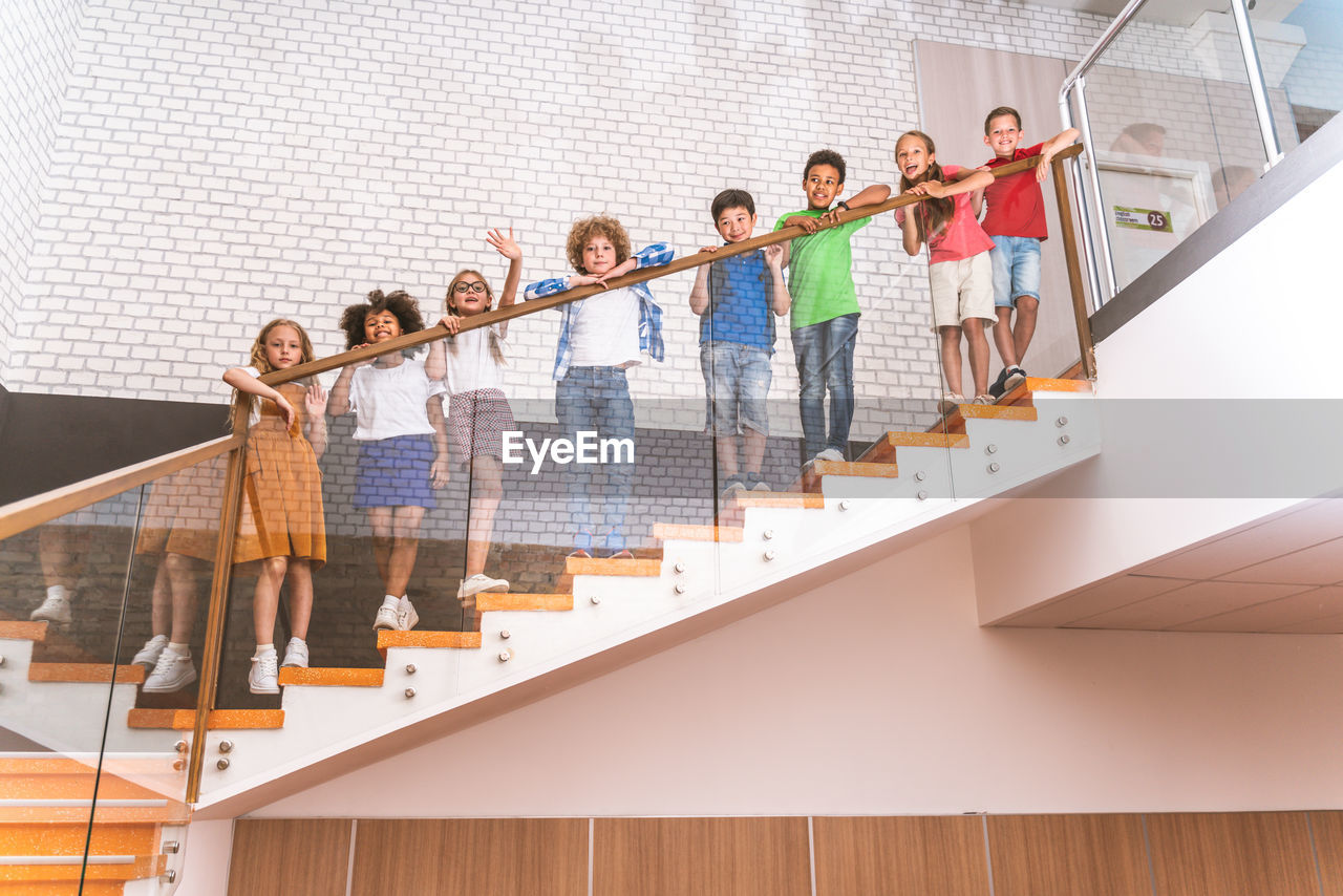 Low angle view of kids standing on staircase