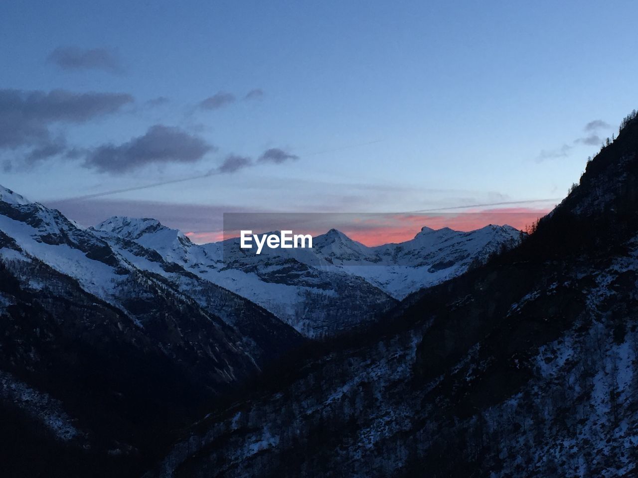 Scenic view of snowcapped mountains against sky during sunset