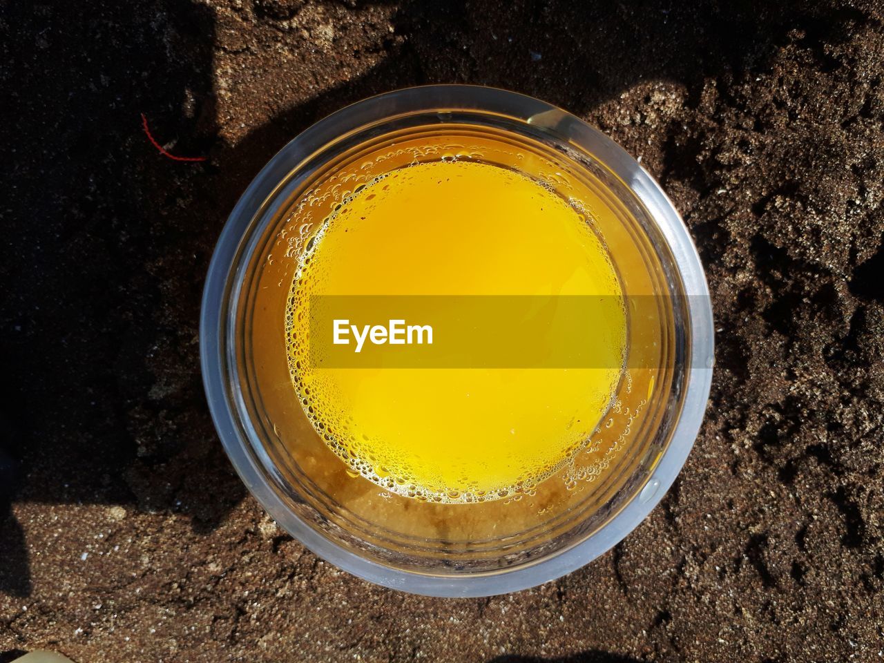 HIGH ANGLE VIEW OF YELLOW GLASS ON TABLE