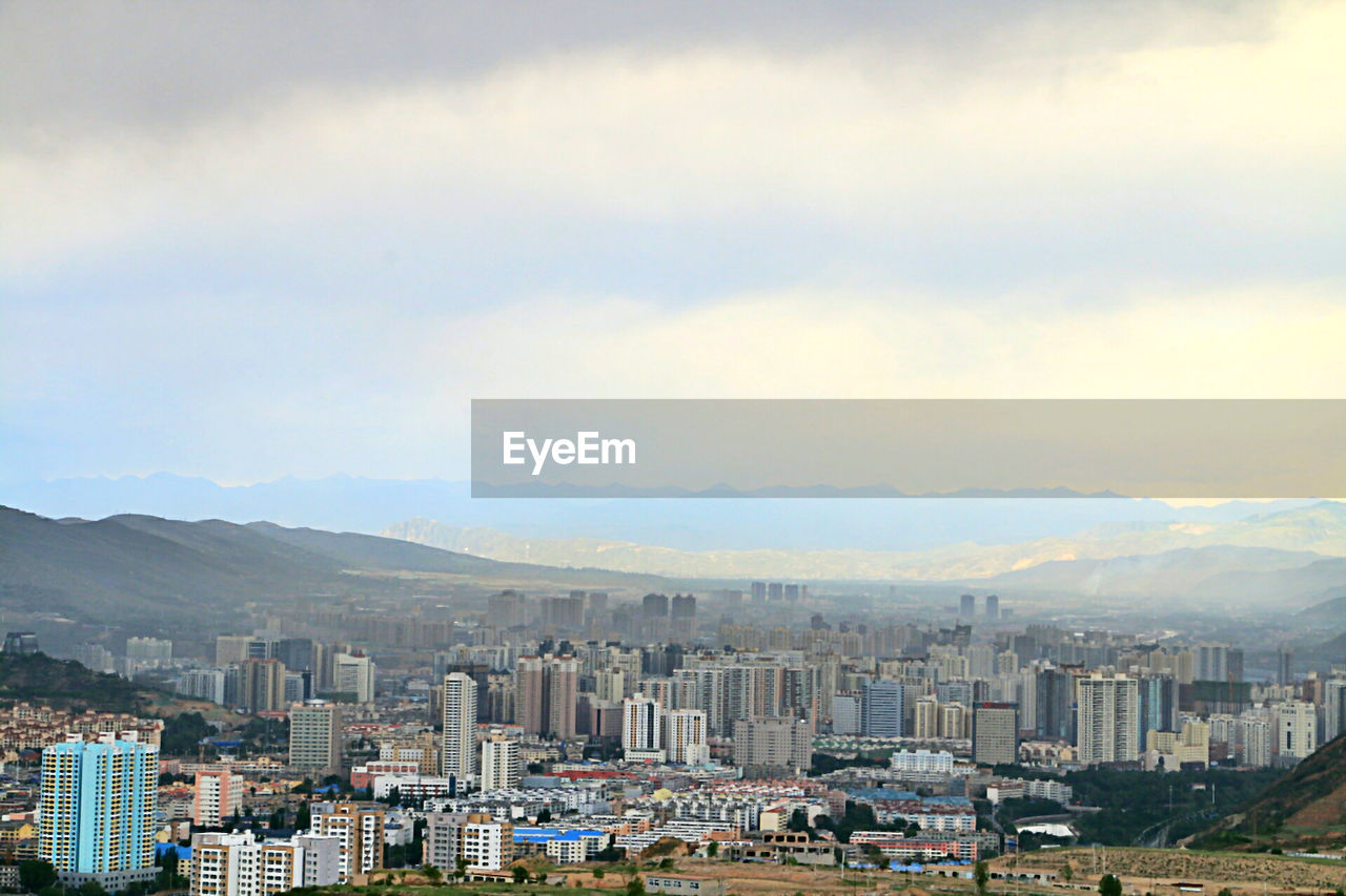 Cityscape against cloudy sky