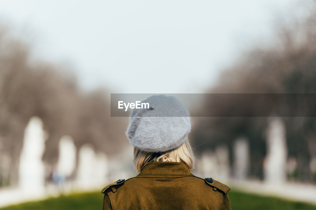 Rear view of woman looking at tree against sky