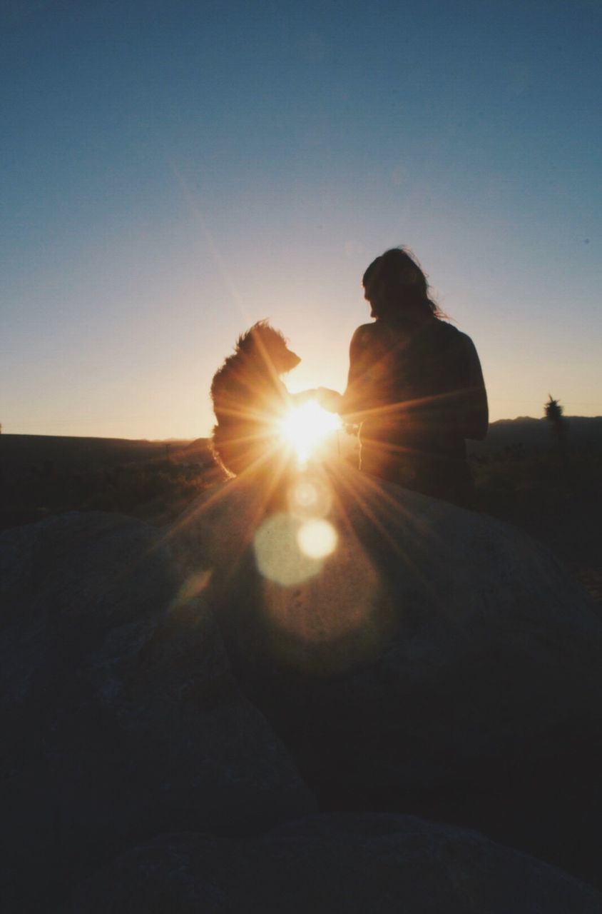 SILHOUETTE WOMAN SITTING AT SUNSET AGAINST SKY