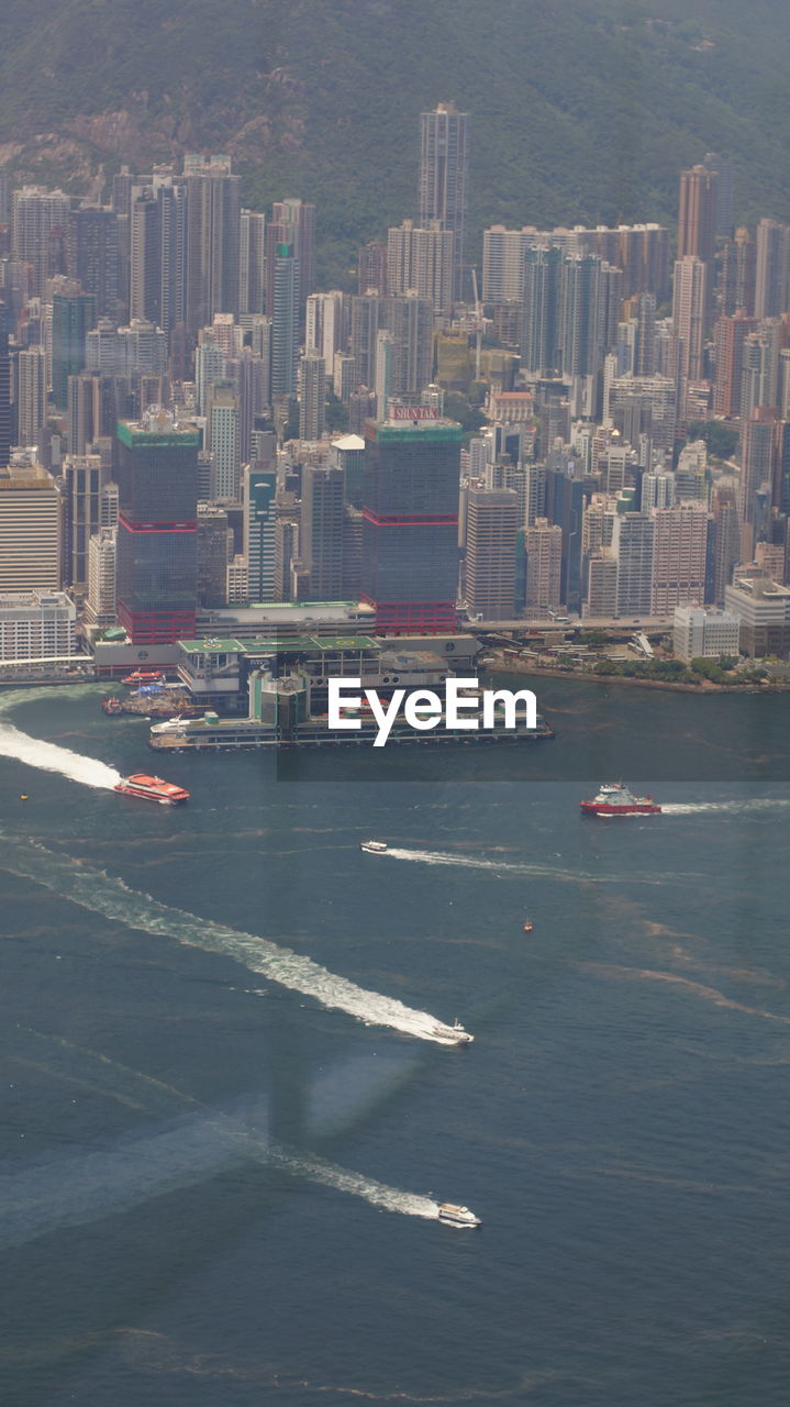 HIGH ANGLE VIEW OF MODERN BUILDINGS BY SEA