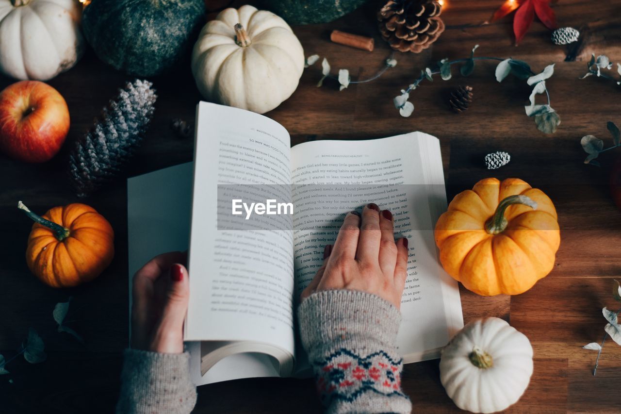 Low angle view of hand holding book on table