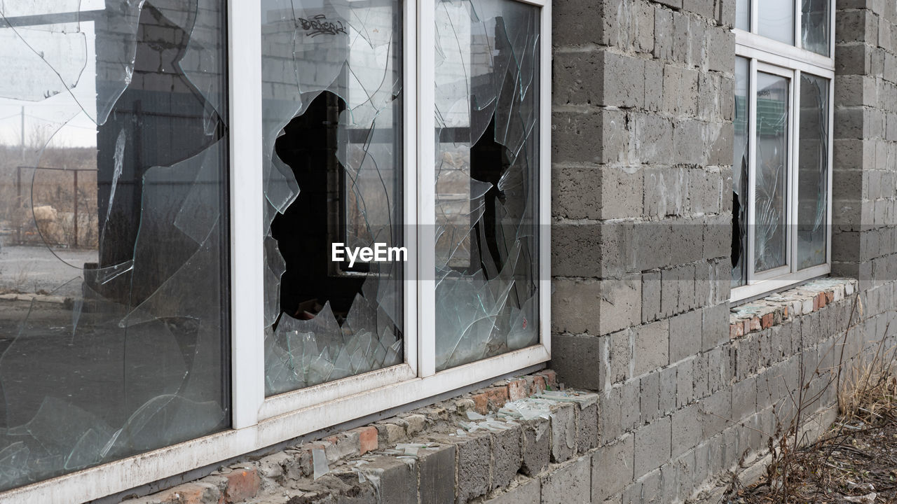 window, architecture, building exterior, built structure, wall, urban area, glass, building, facade, reflection, street, day, abandoned, city, road, no people, damaged, house, broken, outdoors, residential district, wall - building feature, iron