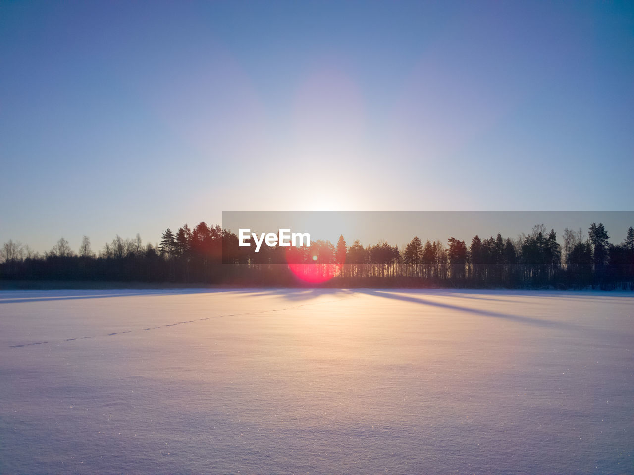 Scenic view of frozen landscape against clear sky during winter