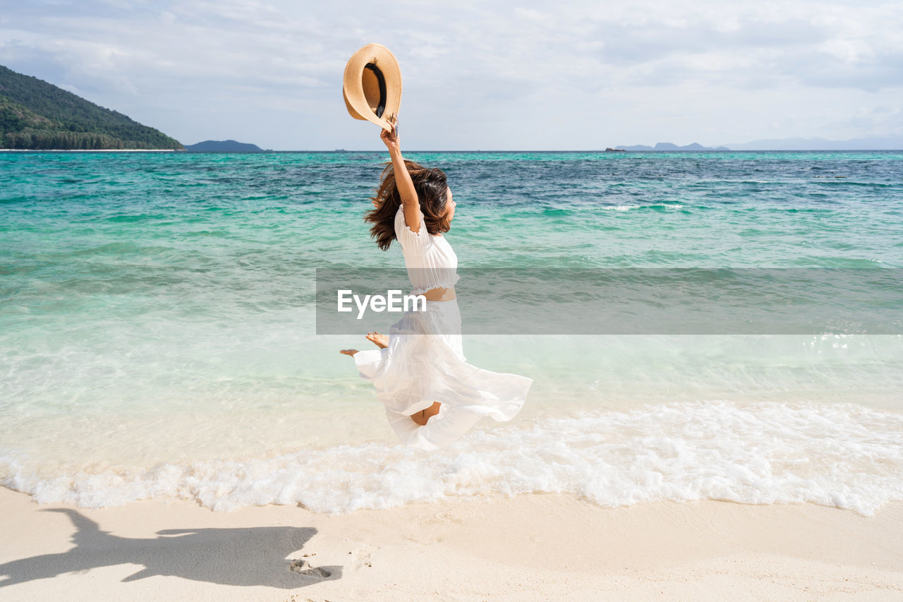 FULL LENGTH OF YOUNG WOMAN ON BEACH