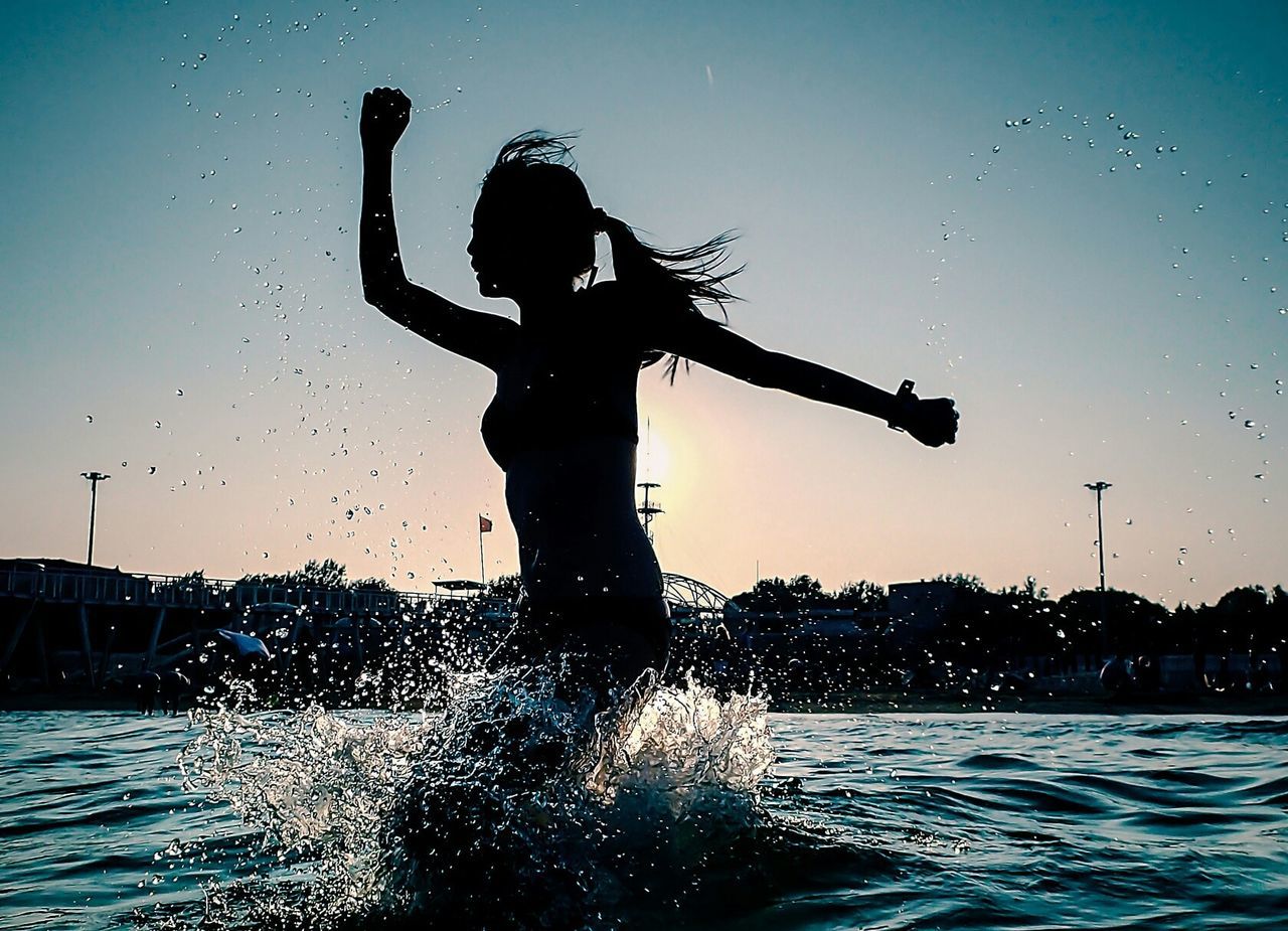 Silhouette of young woman in sea