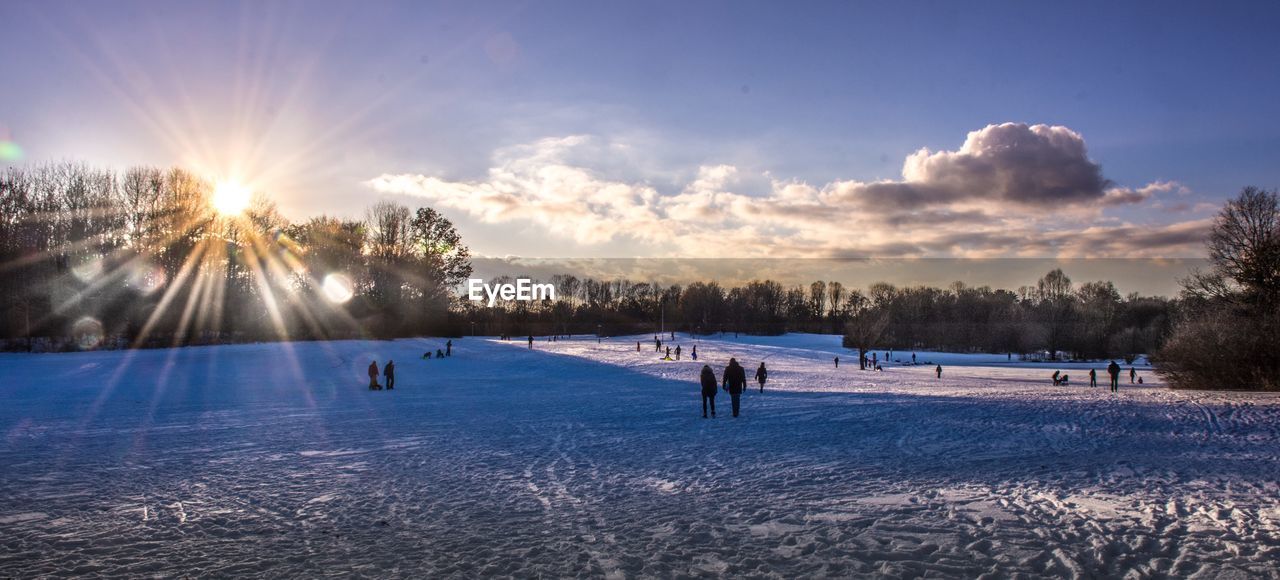 SCENIC VIEW OF SNOWY FIELD AGAINST SKY DURING SUNSET